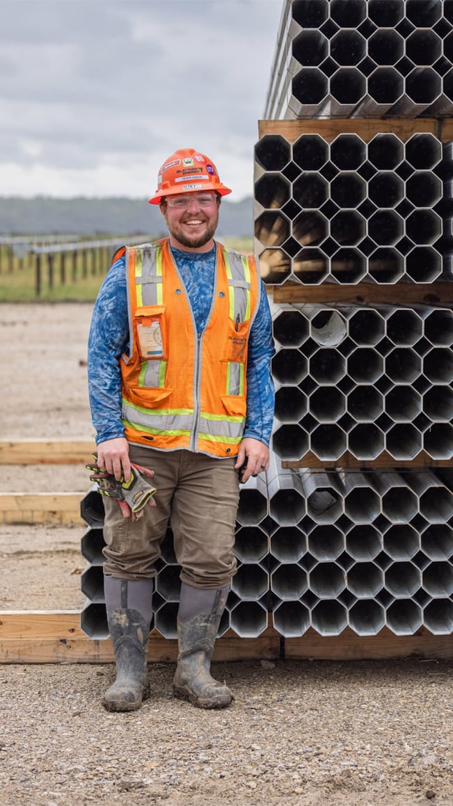 Field employee standing in front of building materials