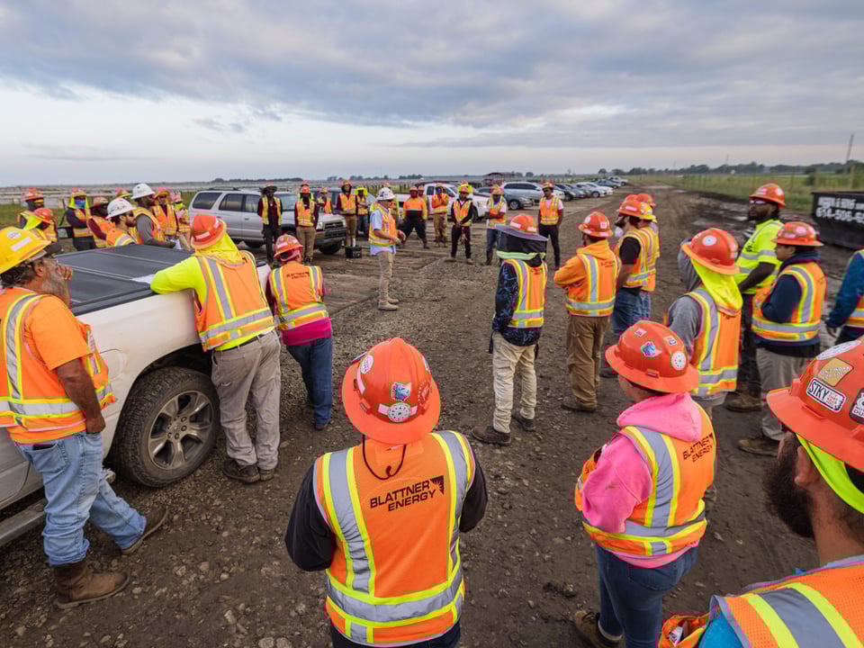 Field team gathering for a meeting outside on the jobsite