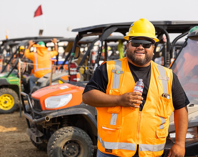 field worker standing in front of vehicles