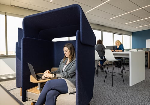 woman sitting in privacy pod